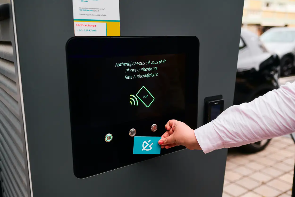 ubitricity product image of a  EV driver holding a charge card on a display of a DC rapid charging station for high-power charging up to 300kW in Le Havre, France.