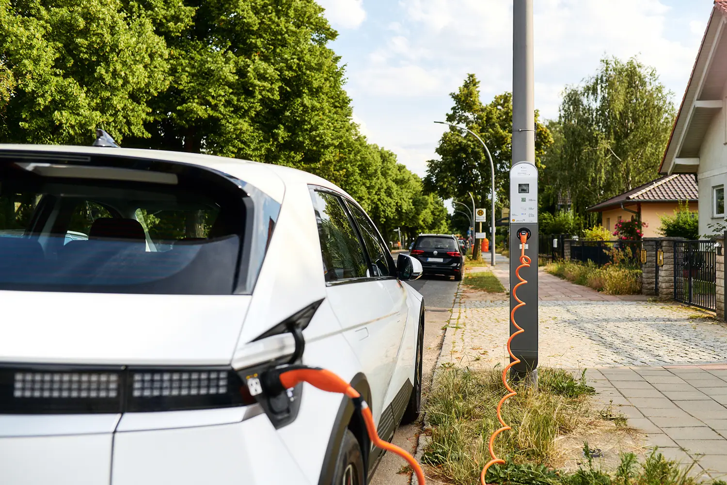 Aufladen eines E-Autos an einer öffentlichen ubitricity AC-Laternenladestation, in einem Wohngebiet in Berlin, Deutschland