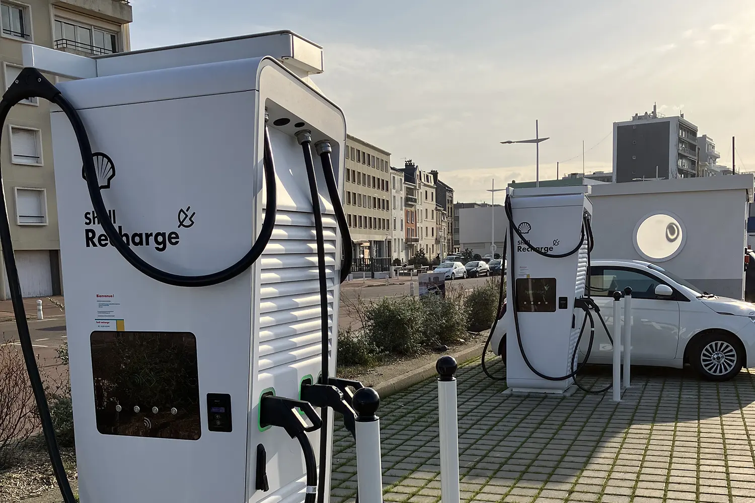 Une voiture électrique recharge sa batterie sur une borne de recharge rapide publique d'ubitricity et de Shell Recharge au Havre.