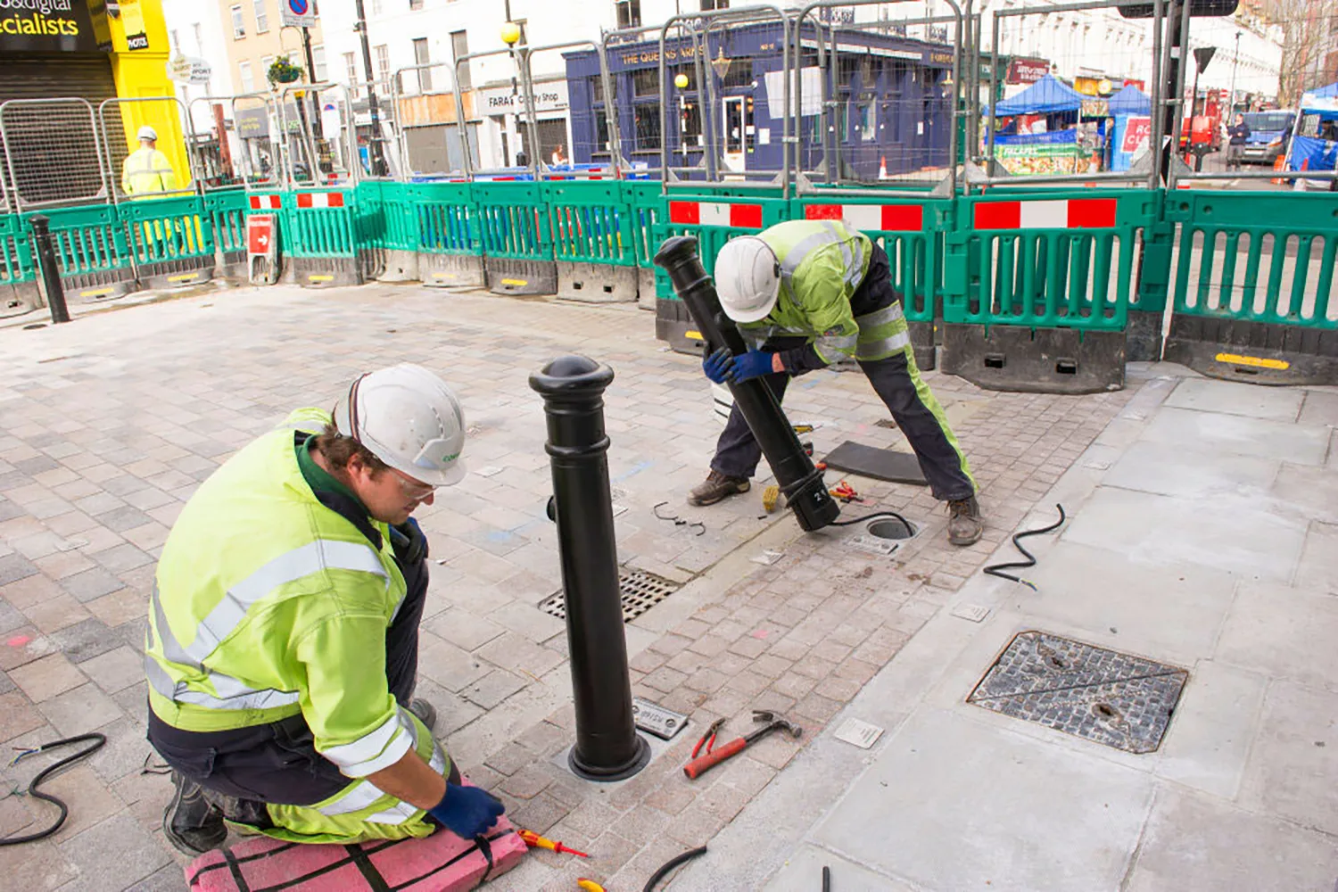 Two electricians are installing ubitricity bollard charge points at Tachbrook Market, London, one of ubitricity's UK projects.