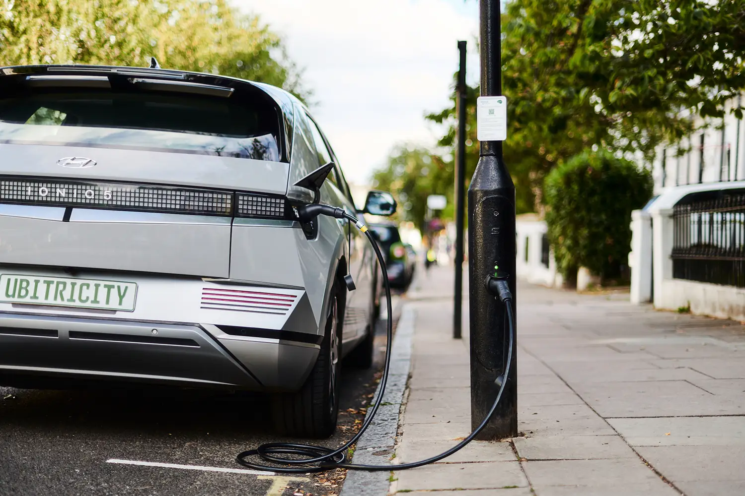An electric vehicle charges at a ubitricity lamppost charging station, a charging solution to expand public charging infrastructure.