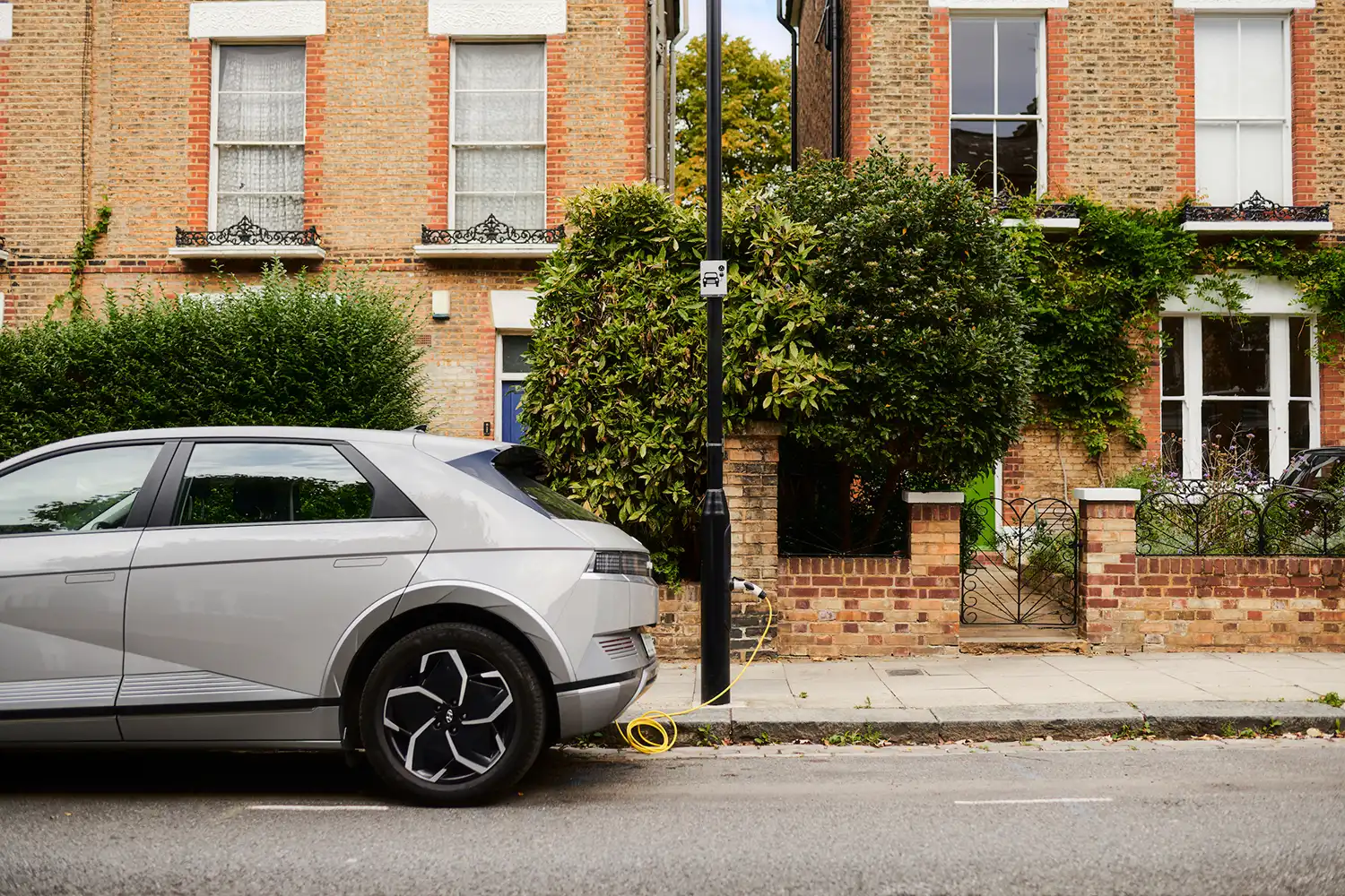 Electric vehicle using an ubitricity lamppost charge point on a residential street in London.