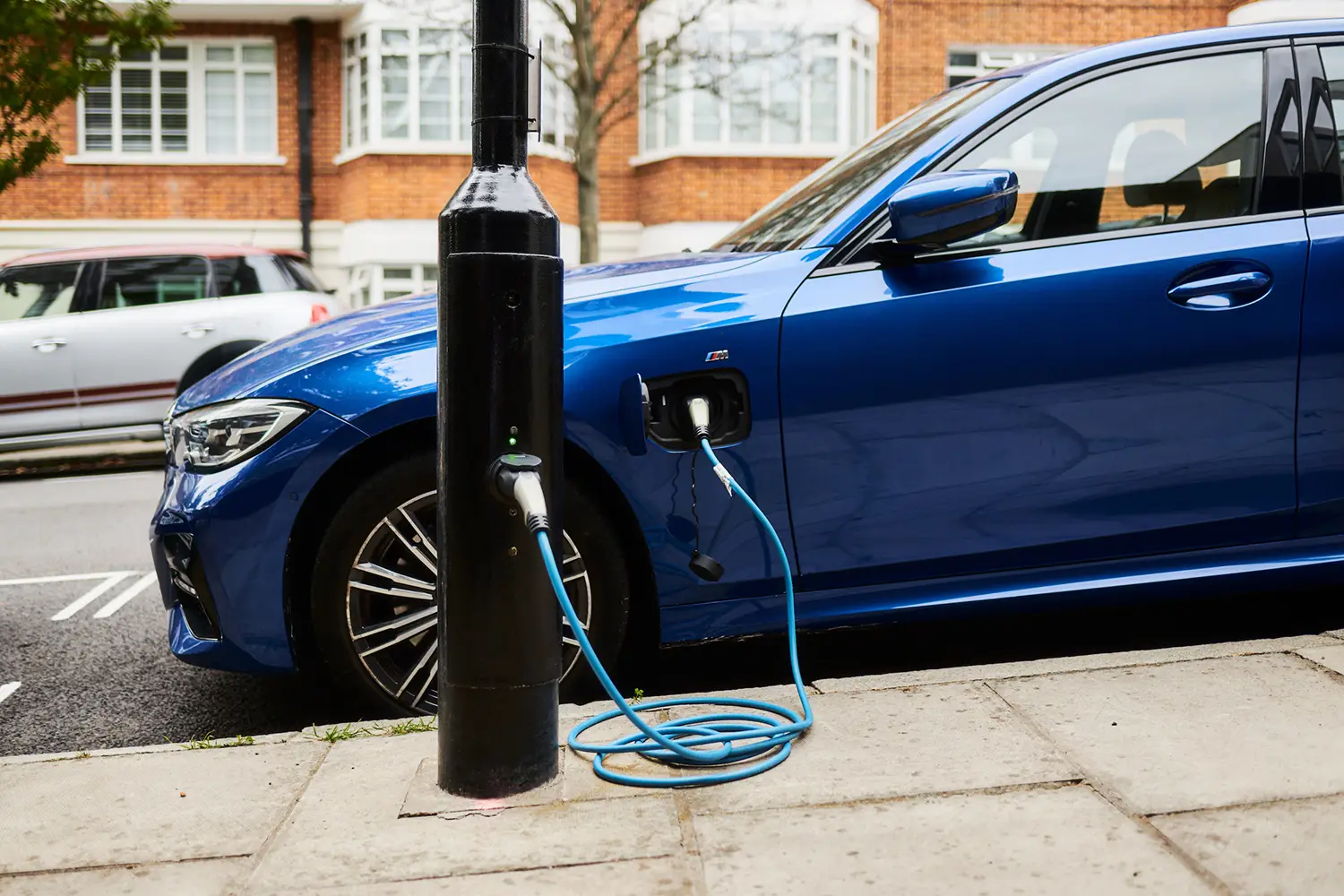 A electric car is charging at an on-street ubitricity charge point retrofitted into an existing lamppost in Westminster, London.