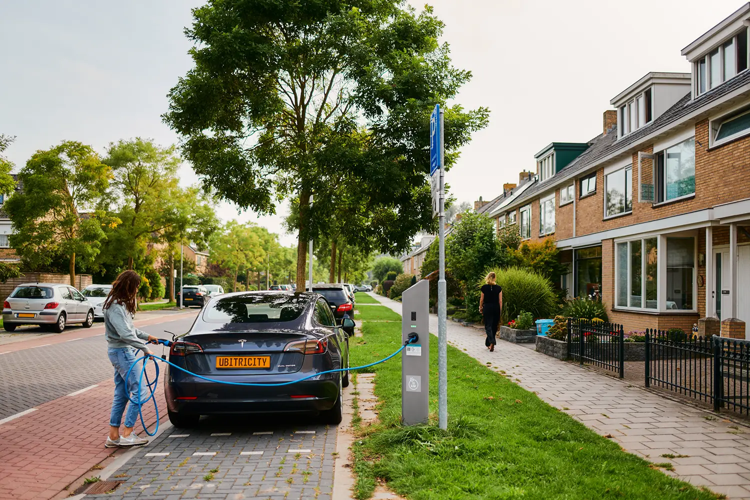 Une conductrice recharge son véhicule électrique à une station de recharge AC publique de Shell ubitricity aux Pays-Bas, un projet de référence de l'opérateur de points de recharge.