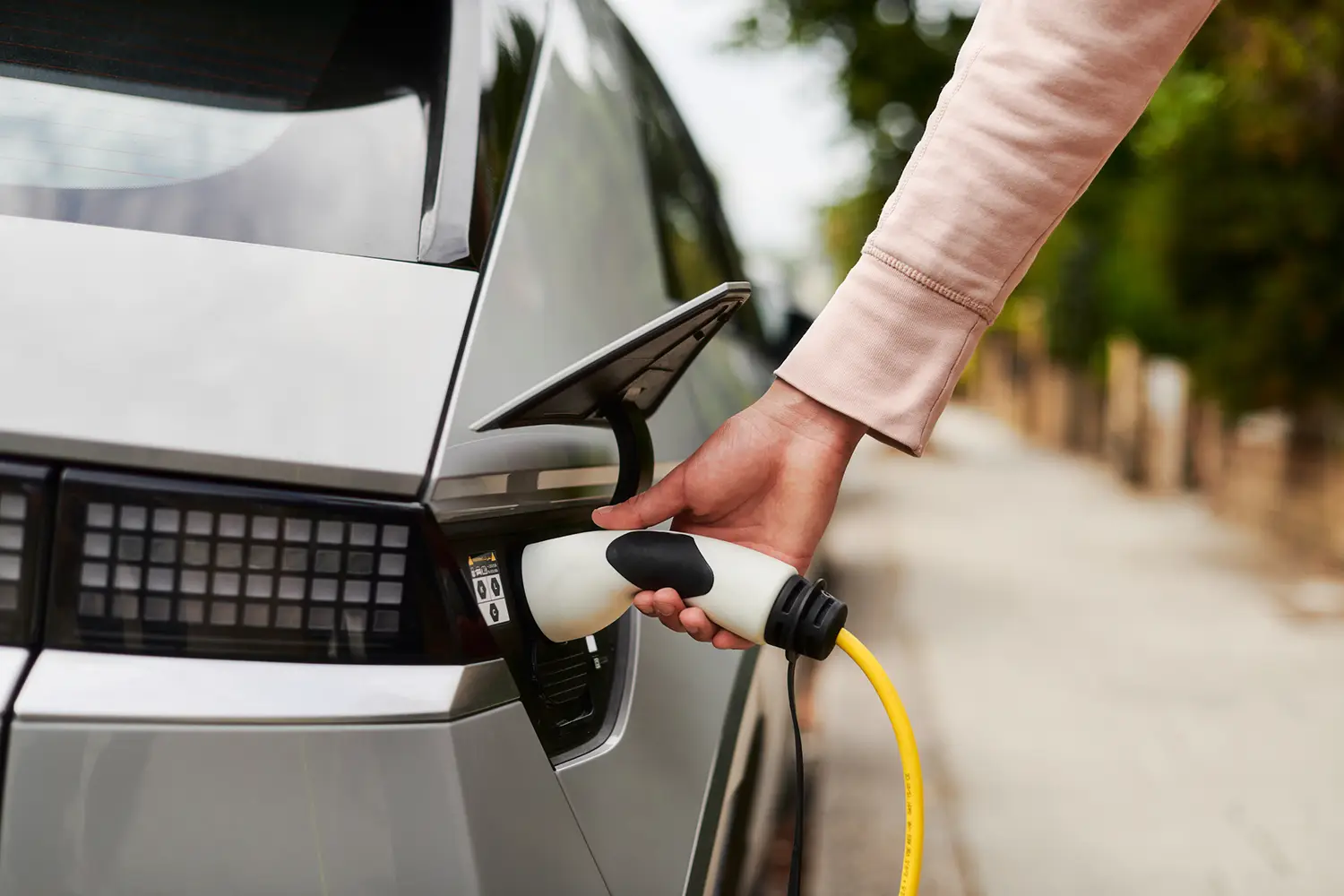 A driver is releasing his charging cable after charging at an ubitricity-operated Shell Recharge charging station at which payments are made on a kWh basis.