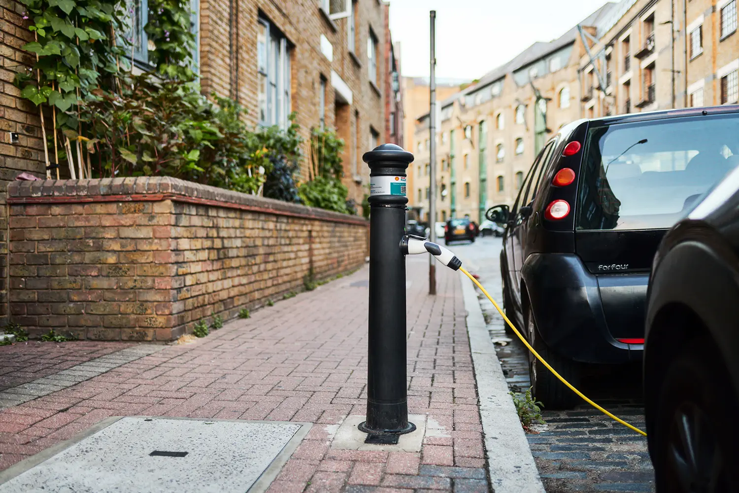 An electric vehicle is charging at an ubitricity-operated Shell Recharge lamppost bollard charge point, offering fair prices, tariffs and costs on a kWh basis.