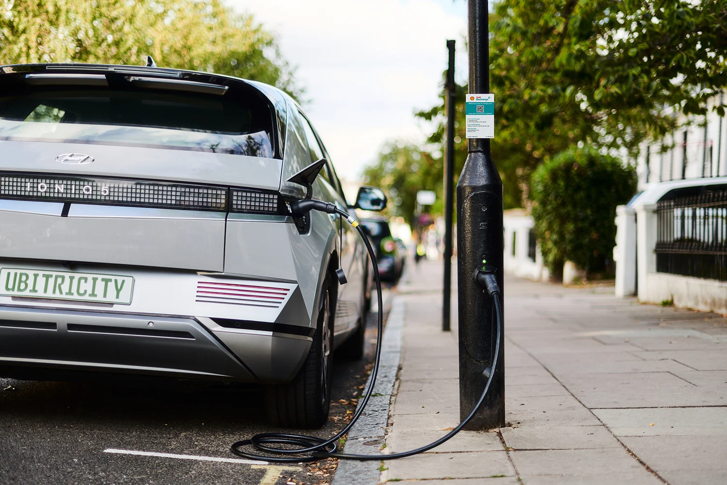 An electric vehicle is charging at a public Shell Recharge lamppost charge point, operated by Shell's subsidiary ubitricity.