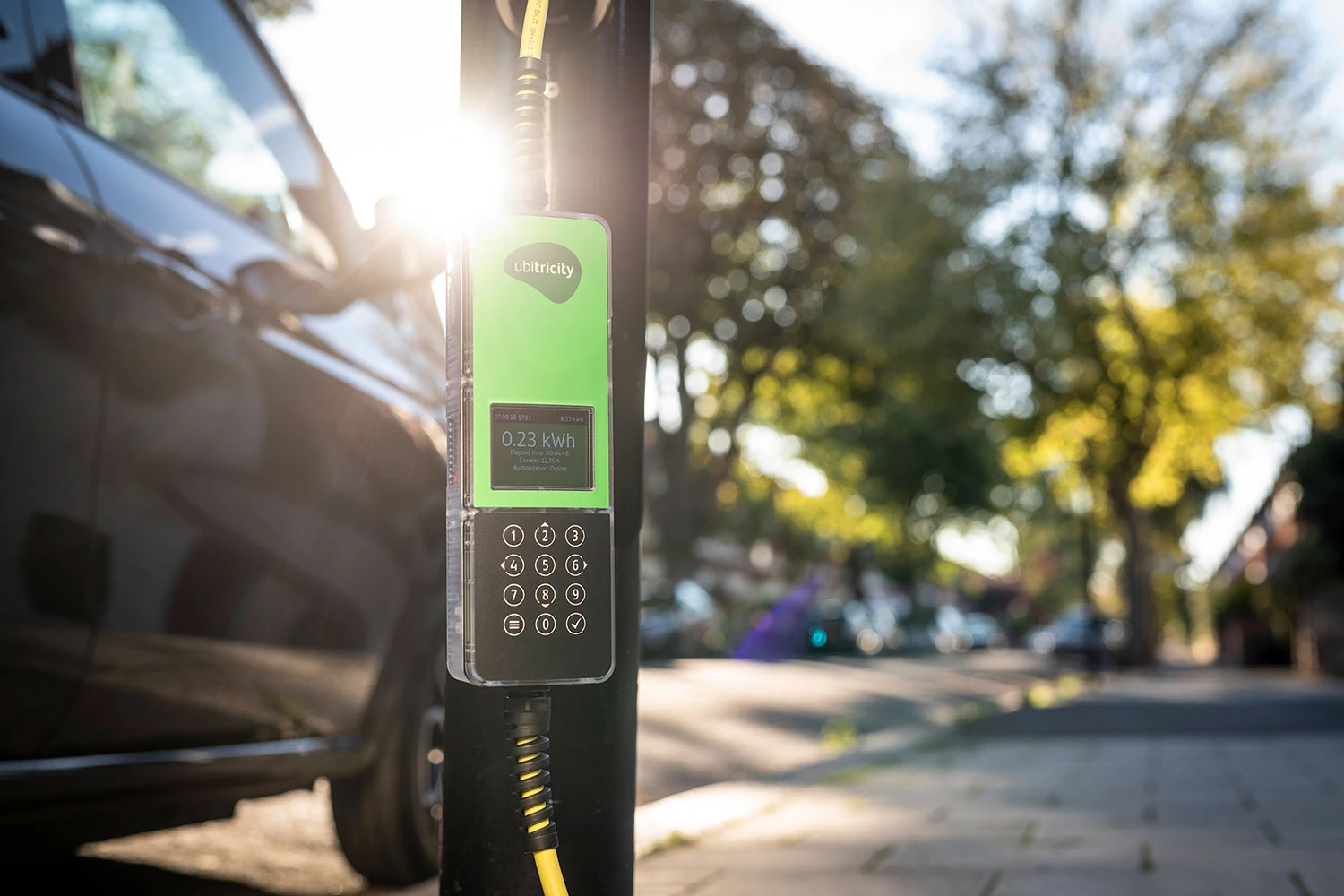 An EV is connected to a charging station with a phased-out ubitricity Smart Cable, which offered convenient charging at fixed rates.